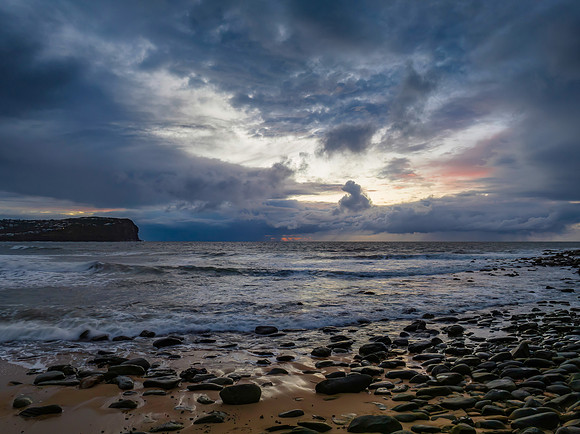Moody sunrise seascape with rain clouds