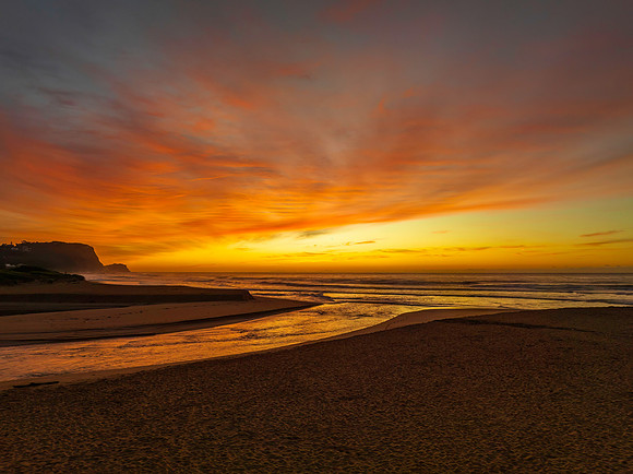 Sunrise and high cloud cover by the sea and lagoon