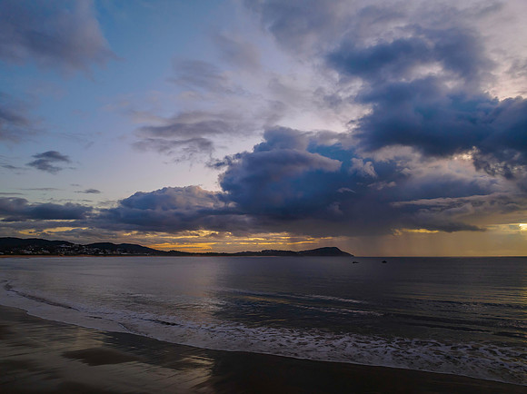 Aerial sunrise at the seaside with rain clouds