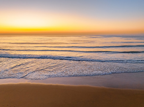 Aerial sunrise at the beach with clear skies
