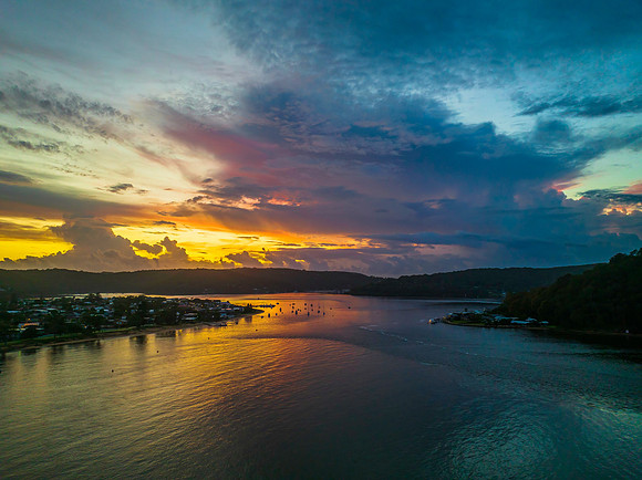 Aerial sunrise waterscape with boats, colour and clouds