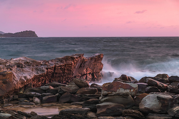 Cloud covered sunrise seascape with rocks