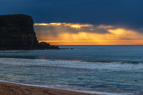 Winter sunrise by the sea shore with rain clouds