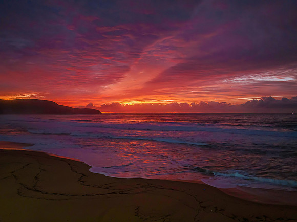 Vibrant cloud covered dawn at the seaside in pink and blue