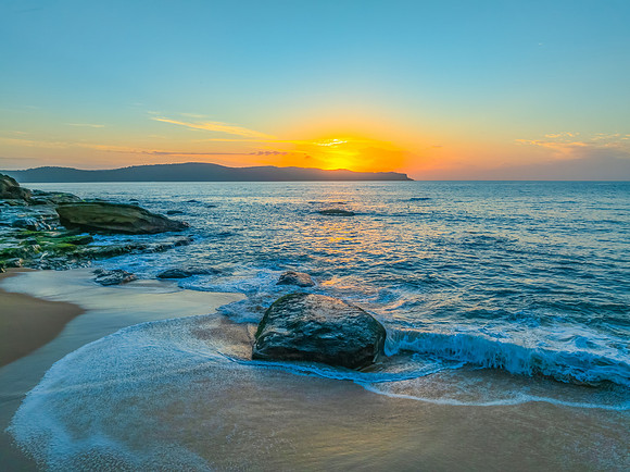 Aerial sunrise at the seaside with light scattered high cloud an