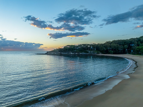 Sunrise over the ocean with clouds and a calm sea