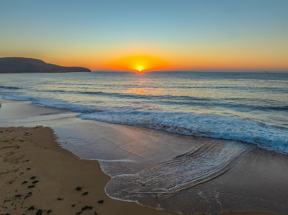 Sunrise seascape with clear skies and orange horizon