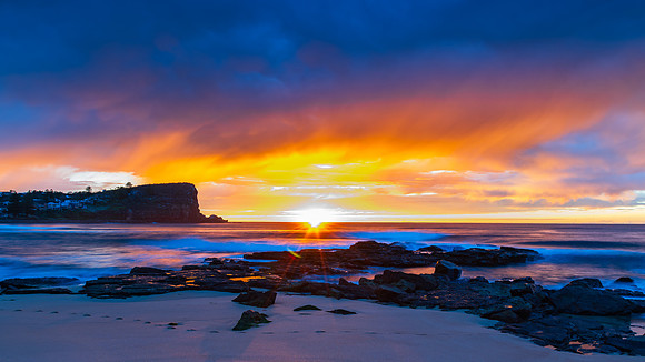 Winter sunrise by the sea shore with rain clouds