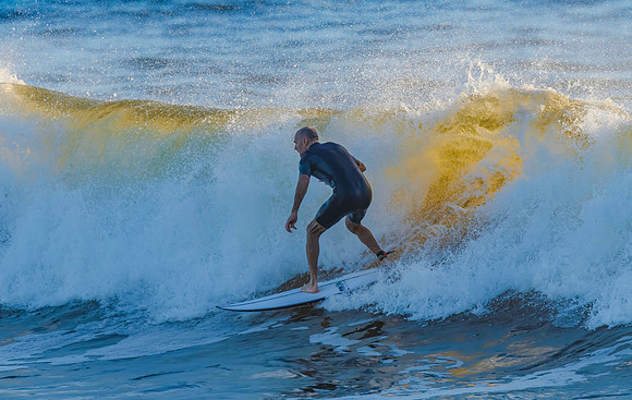 Early morning surfer and waves at the seaside