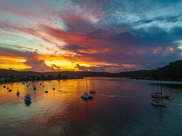 Aerial sunrise waterscape with boats, colour and clouds