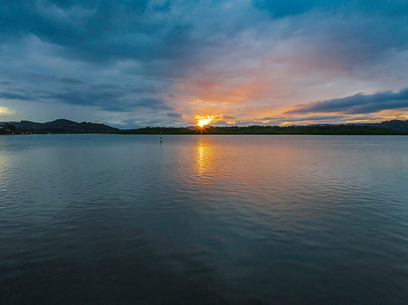 The sun trying to burst through the rain clouds and shine over t