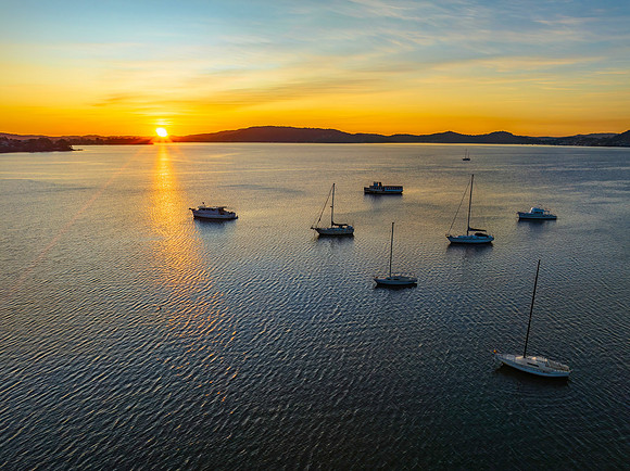 Aerial sunrise waterscape with boats and high cloud