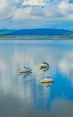 Aerial views over the bay with clouds, reflections and boats