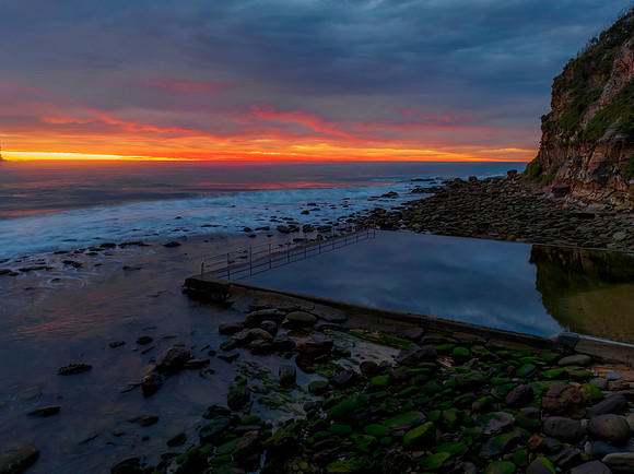 Cloud filled sunrise seascape with sea pool