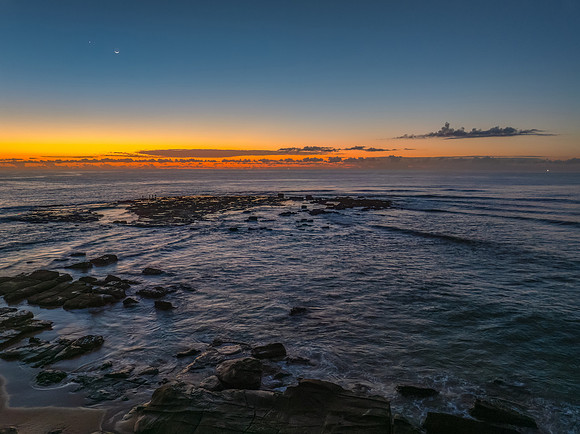 Dawn over the sea and rocks with clear skies