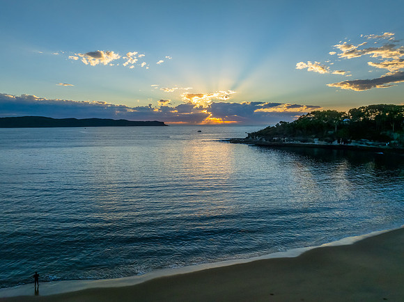 Sunrise over the ocean with clouds and a calm sea