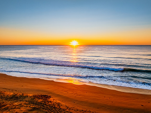 Sunrise at the seaside with clear skies and orange horizon