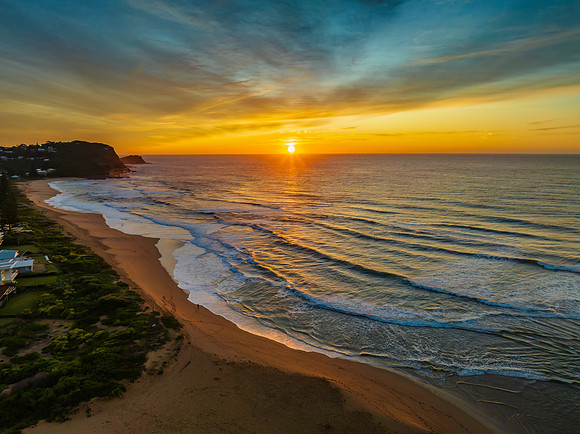 Sunrise and high cloud cover by the sea and lagoon