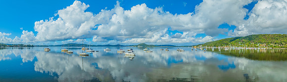 Aerial views over the bay with clouds, reflections and boats