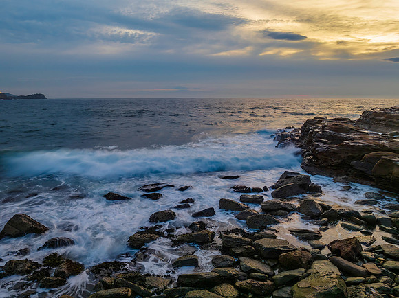 Dreamy soft-hued sunrise seascape over the ocean with high cloud