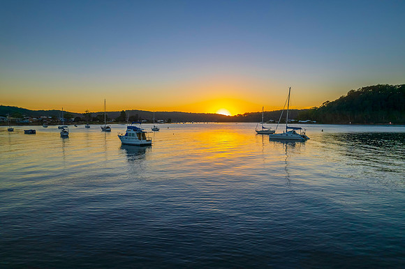 Aerial sunrise waterscape with boats and clear skies