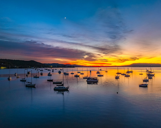Aerial sunrise waterscape with boats and high cloud