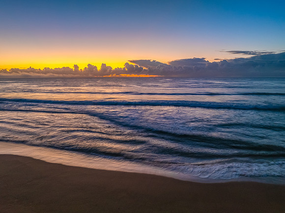 Sunrise over the sea with a low cloud bank and fog