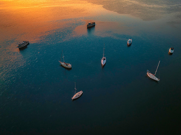 Aerial sunrise top down waterscape with boats