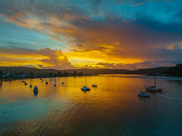 Aerial sunrise waterscape with boats, colour and clouds
