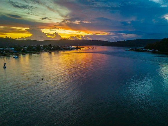 Aerial sunrise waterscape with boats, colour and clouds