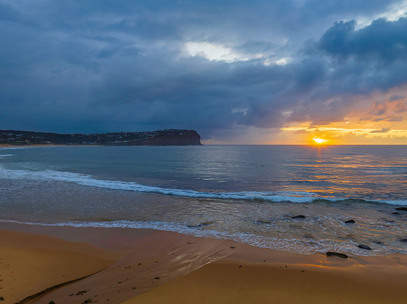 Drizzly moody sunrise seascape with cloud filled sky