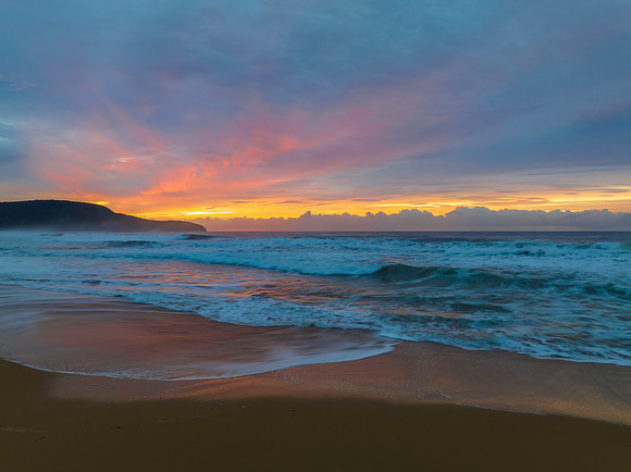 Cloud covered sunrise at the seaside in soft pastel shades