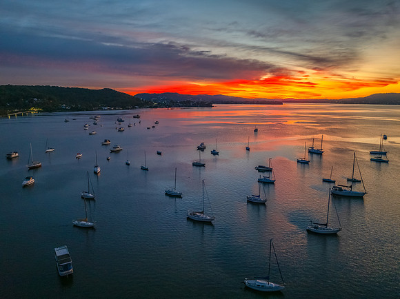 Aerial sunrise waterscape with boats and high cloud