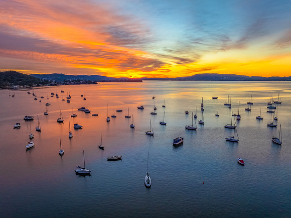 Aerial sunrise waterscape with boats and high cloud
