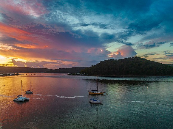 Aerial sunrise waterscape with boats, colour and clouds