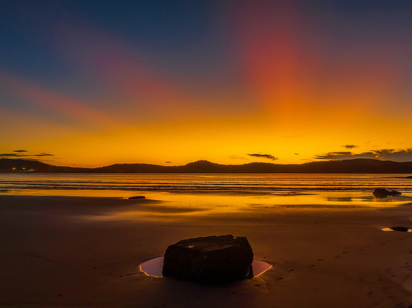 Aerial sunrise at the beach with sun rays in a clear sky