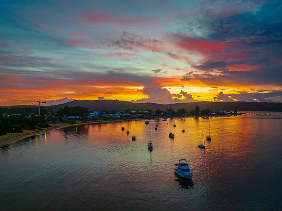 Aerial sunrise waterscape with boats, colour and clouds