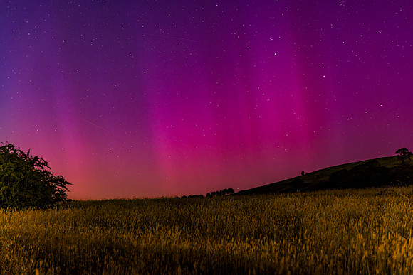 Aurora Australis display lights up the predawn sky in pinks