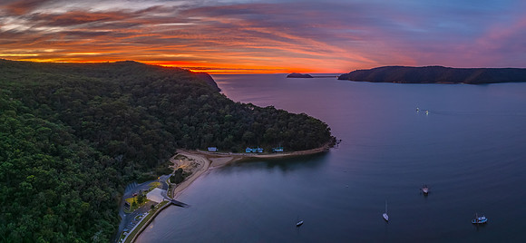 Sunrise over the bay with boats and cloud covered sky