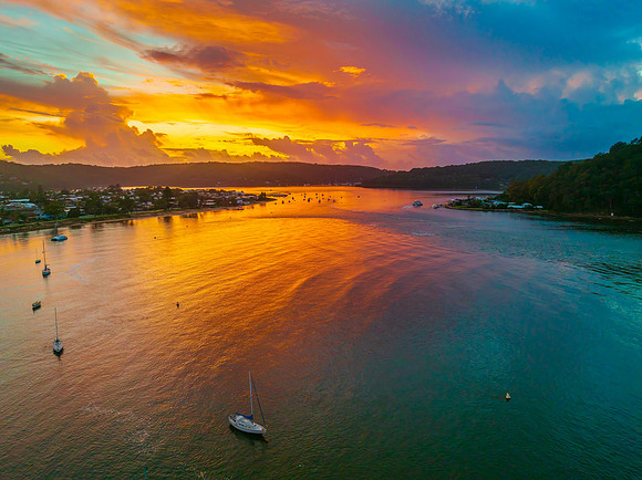 Aerial sunrise waterscape with boats, colour and clouds