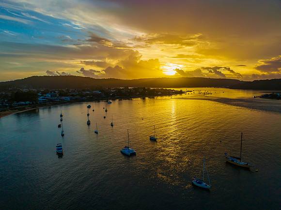 Aerial sunrise waterscape with boats, colour and clouds