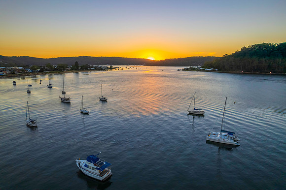 Aerial sunrise waterscape with boats and clear skies