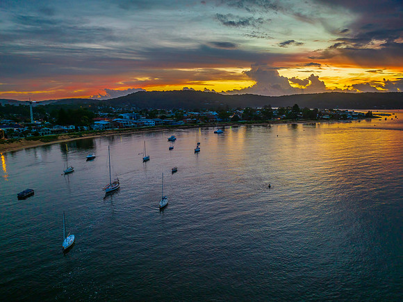 Aerial sunrise waterscape with boats, colour and clouds