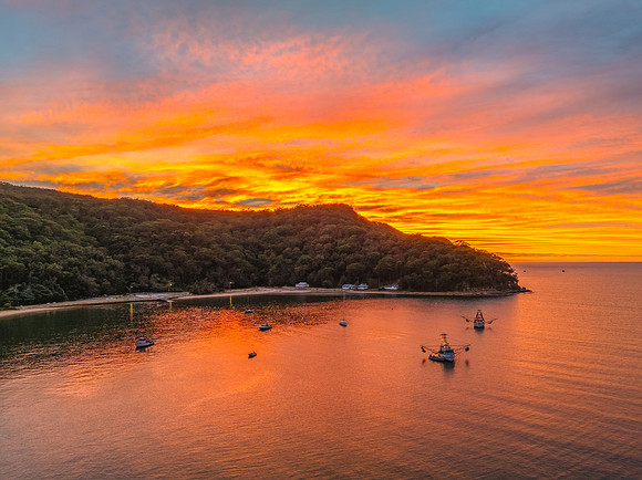 Sunrise over the bay with boats and cloud covered sky
