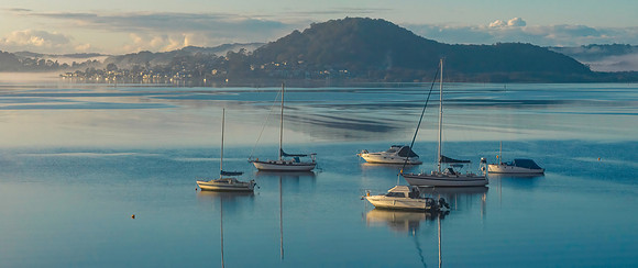 Boats and fog drifting over the bay