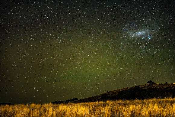 The night sky with magellanic cloud, meteors and diffuse aurora