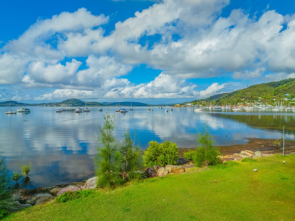 Aerial views over the bay with clouds, reflections and boats