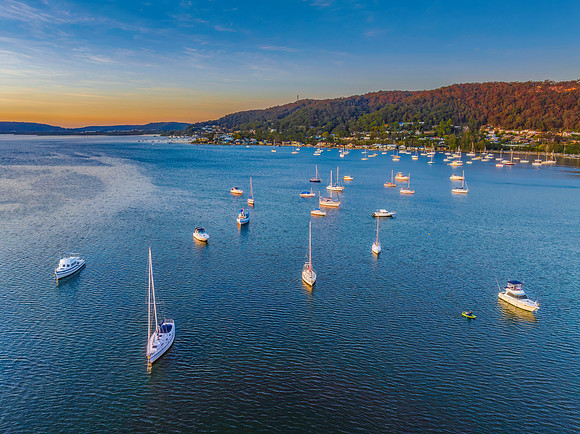 Aerial sunrise waterscape with boats and high cloud