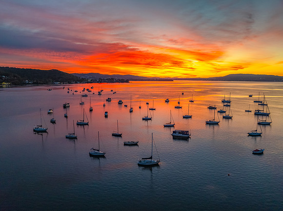 Aerial sunrise waterscape with boats and high cloud