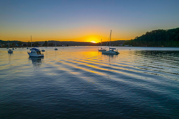 Aerial sunrise waterscape with boats and clear skies
